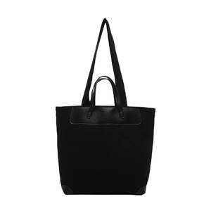 Minimalist black corduroy tote bag with leather handles and adjustable shoulder strap