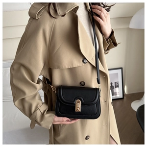 Close-up of a retro black square crossbody bag with a distinctive gold metal lock closure