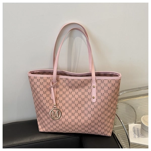 Detail of light pink tote bag with monogram M pattern and gold logo pendant charm