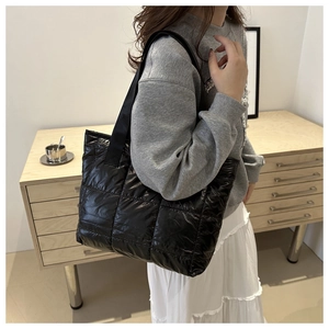 Quilted black puffer tote bag shown on a model in a natural lifestyle setting