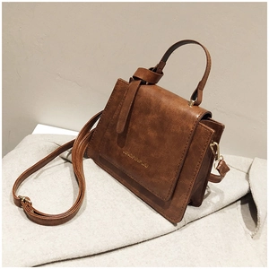 Vue détaillée du sac à main marron vintage avec texture cuir grainé et boucles dorées