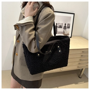 Detail view of the black fuzzy lamb wool tote bag with premium metal rivet accents