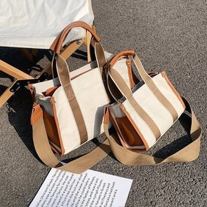 Detailansicht großer und kleiner Canvas-Tragetaschen mit braunem Lederbesatz im Vintage-Stil