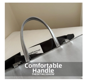 Detail showing double-stitched silver leather handles of a large tote bag for women