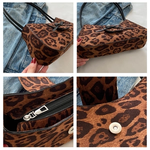 Detail of leopard print baguette bag featuring black ribbon bow and metal zipper closure