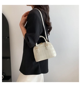 White shell-shaped handbag with diamond quilting and thin adjustable strap detail