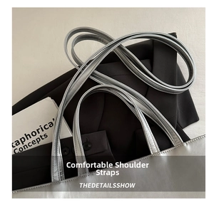 Detail of slim straps on a metallic silver leather tote bag over black blazer