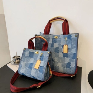 Detailansicht der großen und kleinen Denim-Taschen mit rot gestreiften Tragegriffen