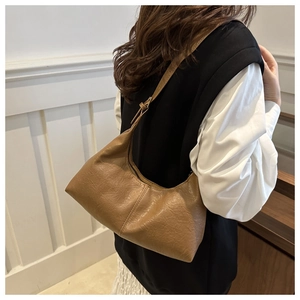 Dettaglio della trama a pieghe e della pelle sintetica marrone sulla borsa baguette vintage
