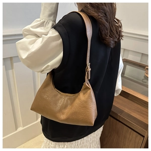 Détail du sac croissant marron vintage avec texture en cuir lisse et bandoulière réglable