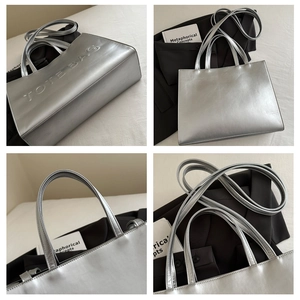 Detail view of silver metallic tote bag with embossed lettering and versatile straps