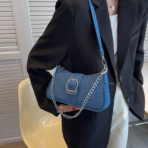 Detailansicht der blauen Denim-Umhängetasche mit weißen Nähten und silberner Schnalle