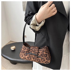 Close-up of leopard print baguette bag with black ribbon bow and dual shoulder straps