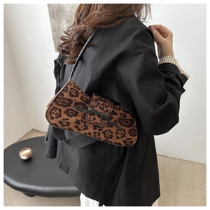 Detailed view of leopard print baguette bag with black bow and slim leather shoulder strap