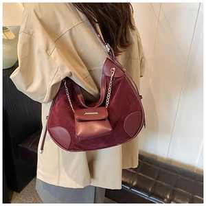 Detail of burgundy hobo bucket bag showing mixed texture suede and smooth leather stitching