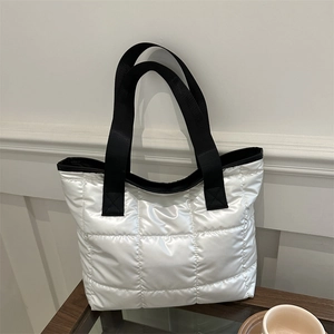 White quilted space cotton tote bag with black straps in minimalist home setting