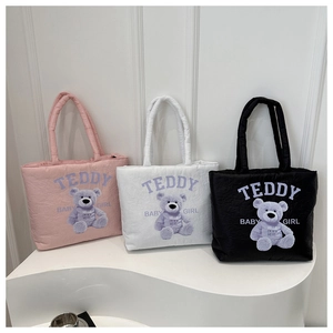 Detailed view of quilted teddy bear tote bags in pink, white, and black colors