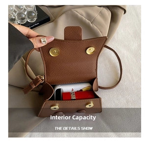 Macro detail of brown litchi grain leather bag interior capacity with golden magnets