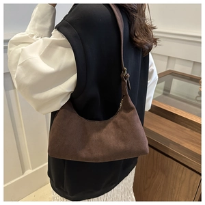 Gros plan du sac hobo en daim marron avec surpiqûres et bandoulière réglable