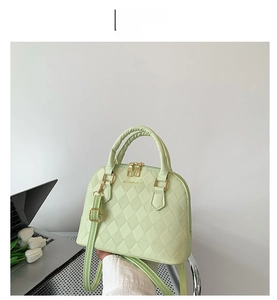 Detail view of mint green shell bag featuring quilted lattice pattern and gold hardware