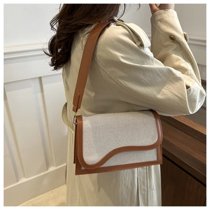 Detail of contrast stitching and wave-edge flap on the two-tone PU crossbody bag