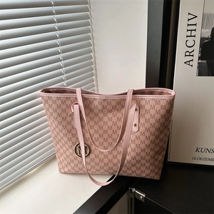 Pink tote bag with all-over M-pattern print and metallic M pendant on long shoulder strap