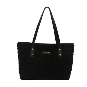 Minimalist black faux fur tote bag with premium leather straps and gold rivets