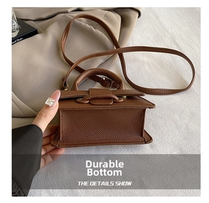 Side and bottom view of brown litchi pattern leather crossbody bag with strap details