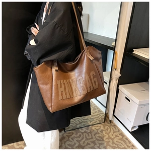Detailed side view of the brown large-capacity tote bag with HNKBAG letter patch