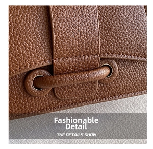 Macro shot of dark brown lychee leather texture and golden metal buckle details