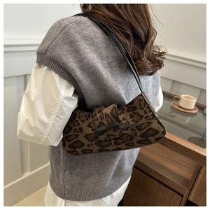 Detail of leopard print baguette bag with black leather bow and dual shoulder straps