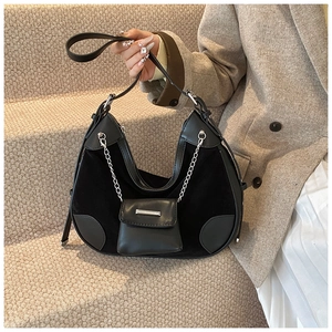 Detail of black patchwork leather bucket bag with silver chain and mini pouch accessory