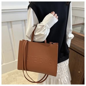 Brown leather tote bag with embossed lettering and detachable shoulder strap for women