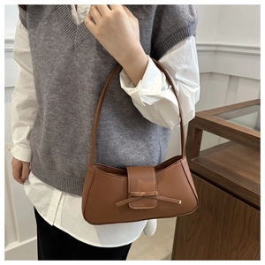 Detailed view of brown PU leather baguette bag featuring a stylish bow and flap closure
