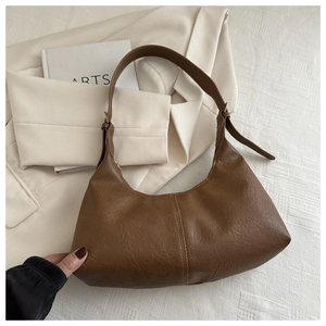 Close-up of vintage brown faux suede tote bag with decorative stitching and adjustable strap
