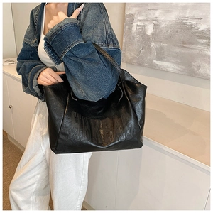 Detail of black faux leather tote bag with HNK BAG embossed lettering and soft texture