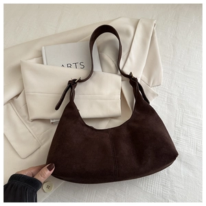 Macro view of dark brown faux suede hobo bag detailing stitching and premium texture