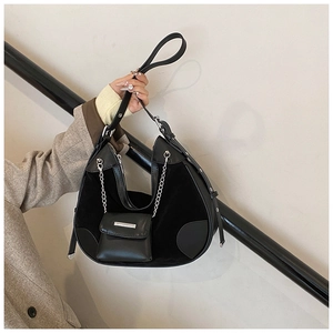 Detail of black leather bucket bag with silver hardware and small hanging pouch accessory