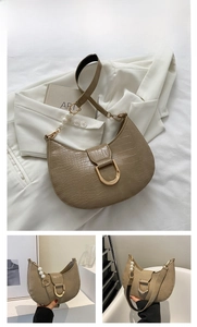 Detail of khaki croc-effect hobo bag featuring pearl strap and golden D-ring buckle