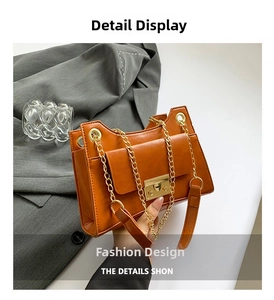 Close-up of orange faux leather crossbody bag featuring gold chain and metal clasp
