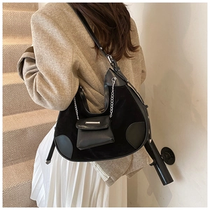 Detail of black crescent hobo bag featuring mixed leather textures and small chain coin purse