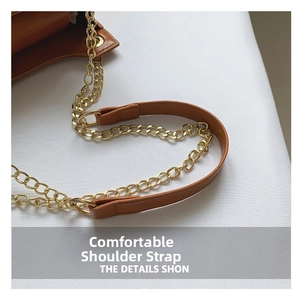 Detail of caramel leather shoulder strap with bright gold metal chain connection