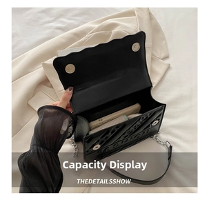 Internal view of black quilted chain bag showing capacity for phone and wallet