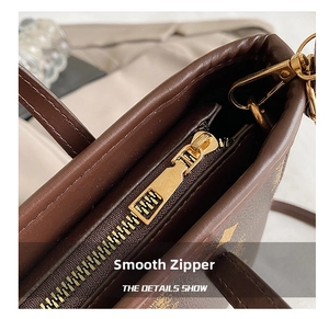 Détail du zip en métal doré et du cuir marron texturé vintage sur le sac seau chic