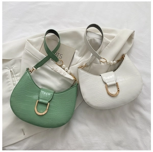Detail of crocodile pattern leather crescent bags with pearl straps and golden D-buckles