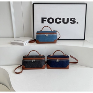 Detailed view of denim patchwork mini bags in light blue, dark blue and black colors