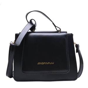 Sac bandoulière chic vintage noir classique avec lettrage doré et poignée sur fond blanc