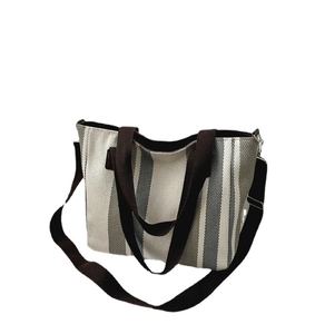 Striped canvas tote bag with brown straps and adjustable shoulder strap for daily commuting