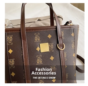 Détail de la texture cuir avec motif ours et plaque en métal doré sur le sac seau