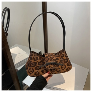 Detail of retro leopard print baguette bag with black bow and soft textured finish